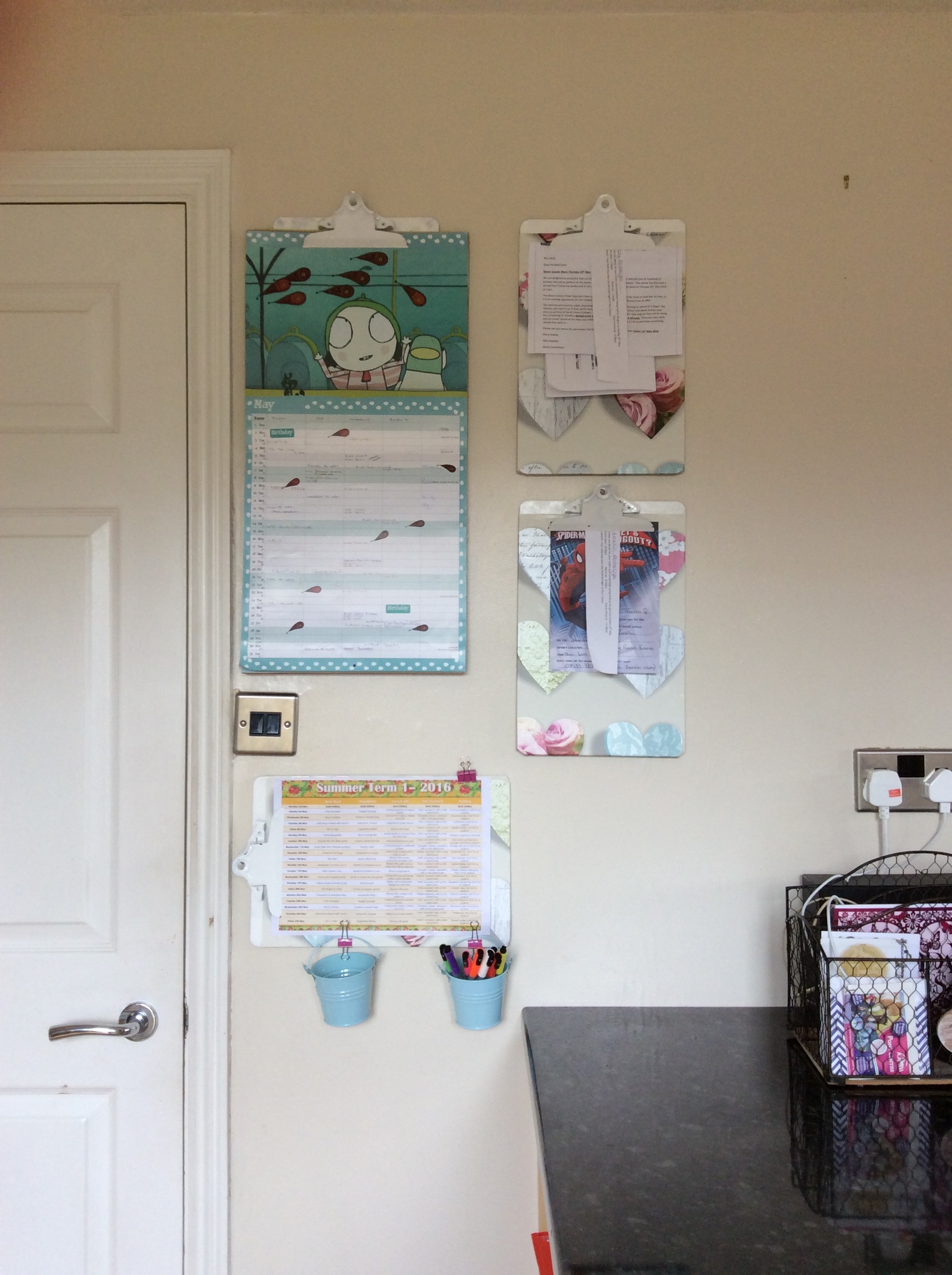 Kitchen wall with clipboards hanging up to hold school paperwork